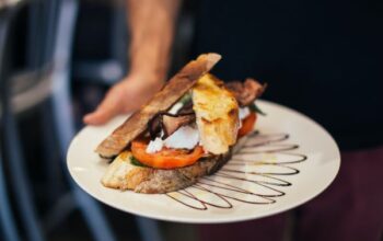 Zdjęcie przedstawiajace serwowane danie - tost, kanapka na pięknie udekorowanym talerzu.